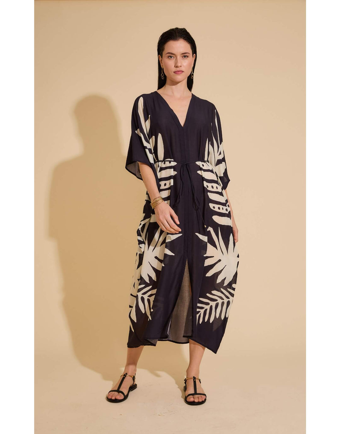 Lenny Niemeyer Frame Kaftan Dress in Jungle with tropical foliage print, V-neckline, loose sleeves, long length, styled over black swimwear.