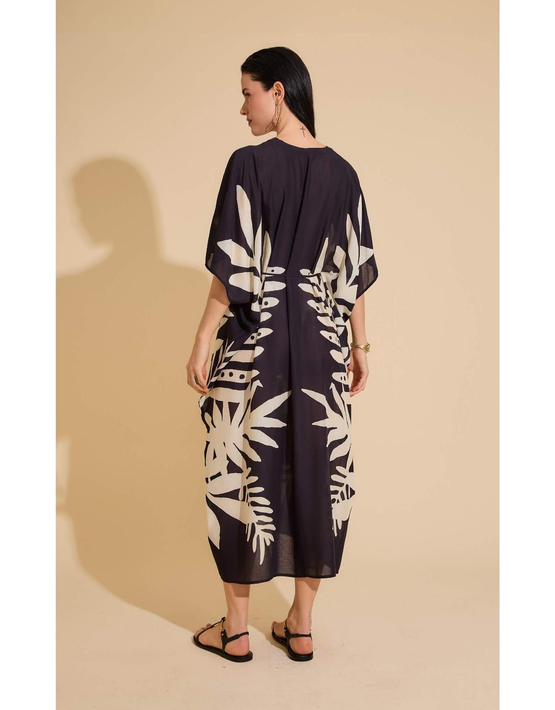 Lenny Niemeyer Frame Kaftan Dress in Jungle with tropical foliage print, V-neckline, loose sleeves, long length, styled over black swimwear.