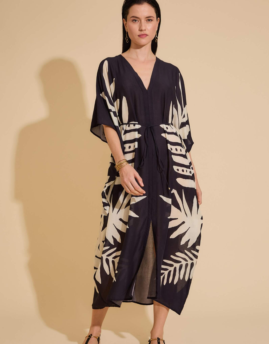 Lenny Niemeyer Frame Kaftan Dress in Jungle with tropical foliage print, V-neckline, loose sleeves, long length, styled over black swimwear.