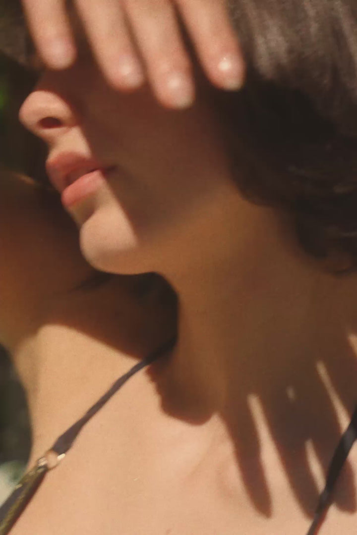 La Nouvelle Gilda one-piece swimsuit in black with gold trim and cross-back straps.