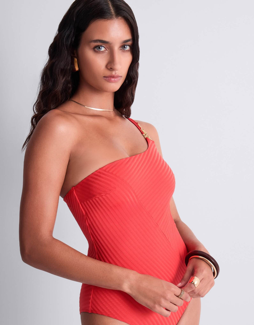 Aubade Sun Pop asymmetrical one‑piece swimsuit in coral, ribbed knit, gold‑tone chain jewel detail