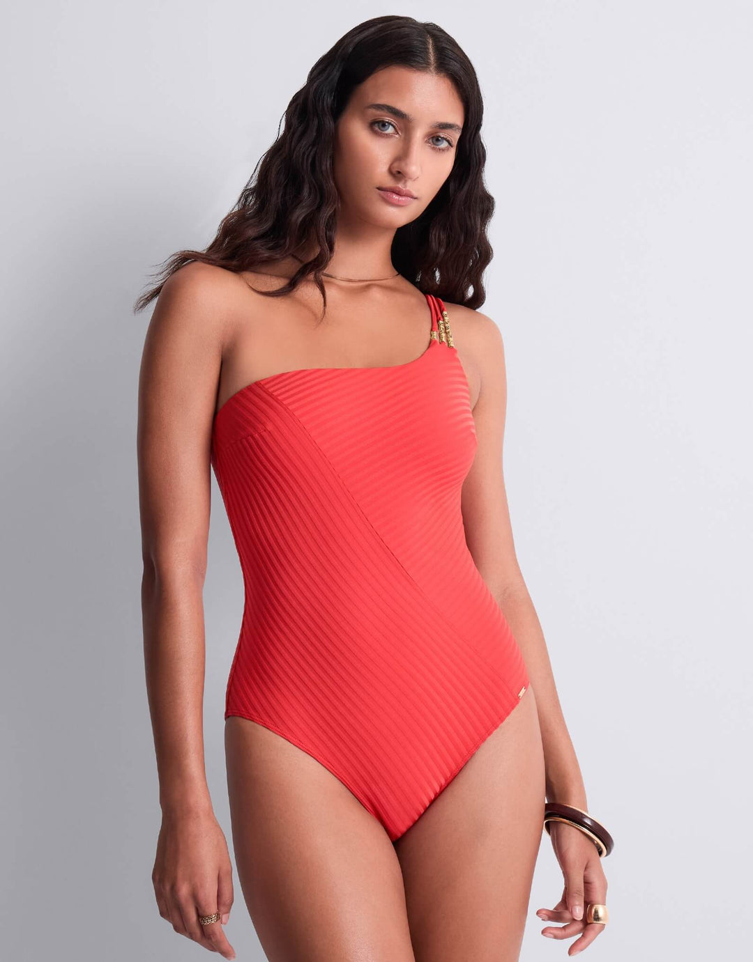 Aubade Sun Pop asymmetrical one‑piece swimsuit in coral, ribbed knit, gold‑tone chain jewel detail