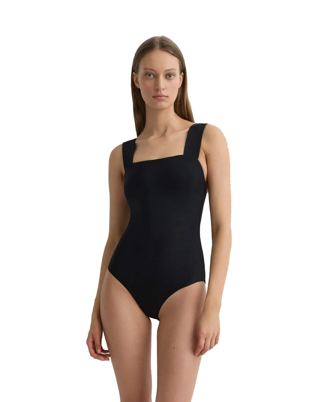 A woman modeling a black one-piece bodysuit with a square neckline and wide shoulder straps, photographed against a plain white studio background.
