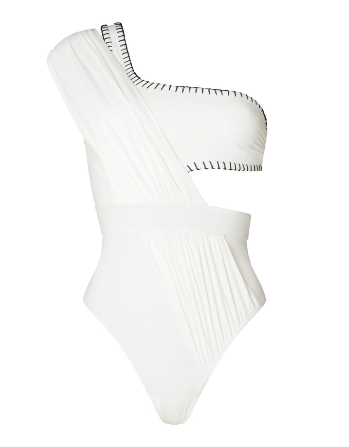 Kióhne Hestia white one-piece swimsuit showing asymmetric draped shoulder, handmade black embroidery trim and cut-out waist detail